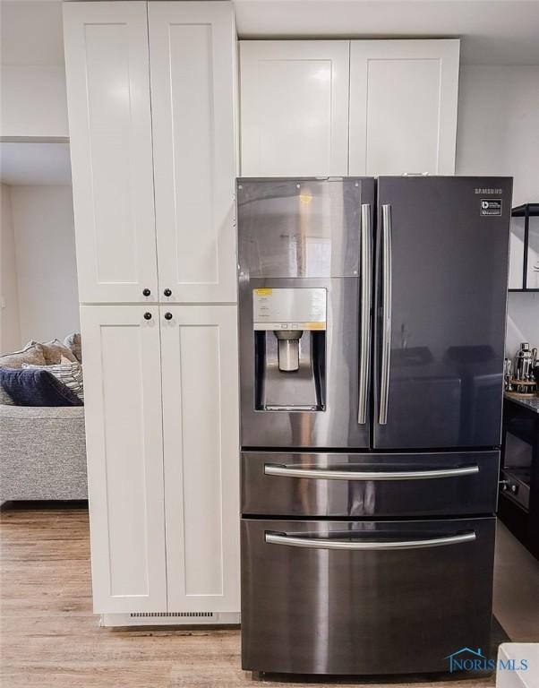 kitchen featuring stainless steel refrigerator with ice dispenser, white cabinets, and light wood-type flooring