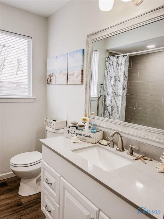 bathroom featuring a shower with shower curtain, vanity, toilet, and hardwood / wood-style floors