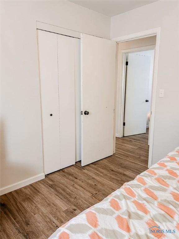 unfurnished bedroom with hardwood / wood-style floors and a closet