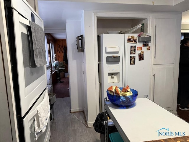 kitchen featuring white refrigerator with ice dispenser and dark hardwood / wood-style flooring