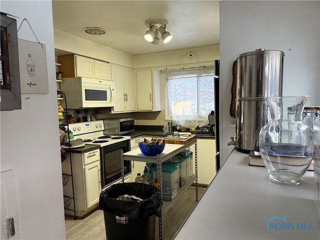 kitchen featuring white appliances and light hardwood / wood-style flooring