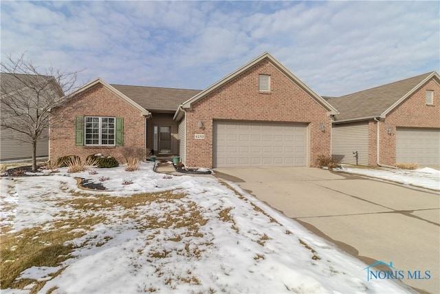 single story home featuring a garage, driveway, and brick siding