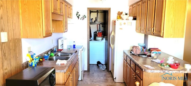 kitchen featuring parquet floors, washer / clothes dryer, sink, and white fridge with ice dispenser