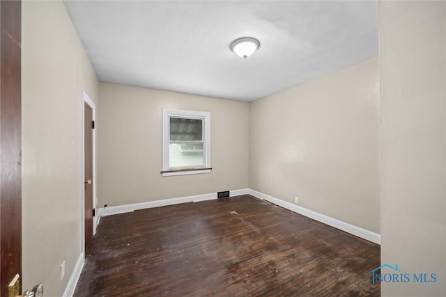 spare room with dark wood-type flooring