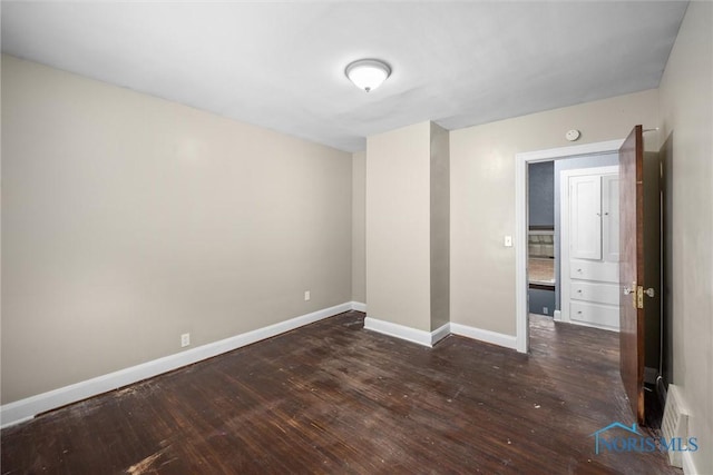 unfurnished room with dark hardwood / wood-style flooring