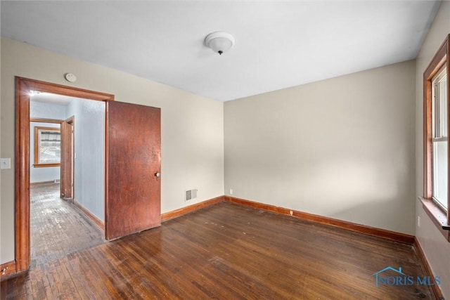 unfurnished room featuring dark hardwood / wood-style flooring and a wealth of natural light