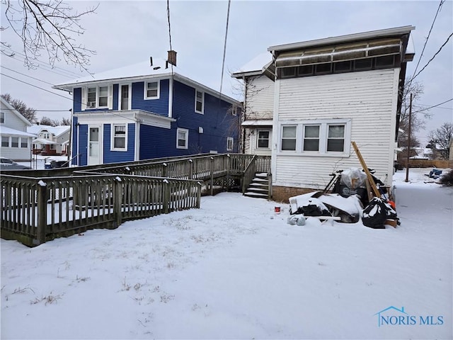 snow covered property with a wooden deck