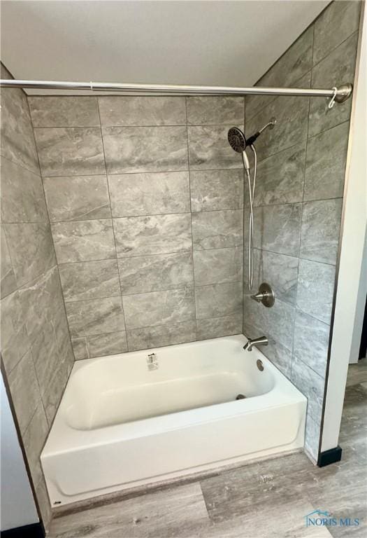 bathroom featuring tiled shower / bath combo and hardwood / wood-style floors