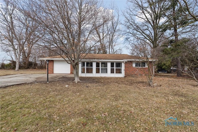 ranch-style house featuring concrete driveway, brick siding, and an attached garage