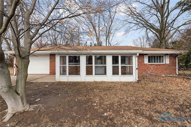 rear view of house with a garage and brick siding