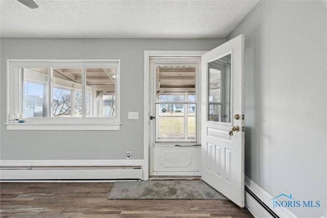 entryway with baseboard heating, a baseboard radiator, and wood finished floors