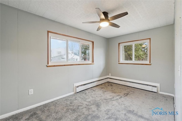 carpeted spare room with a ceiling fan, baseboards, and baseboard heating