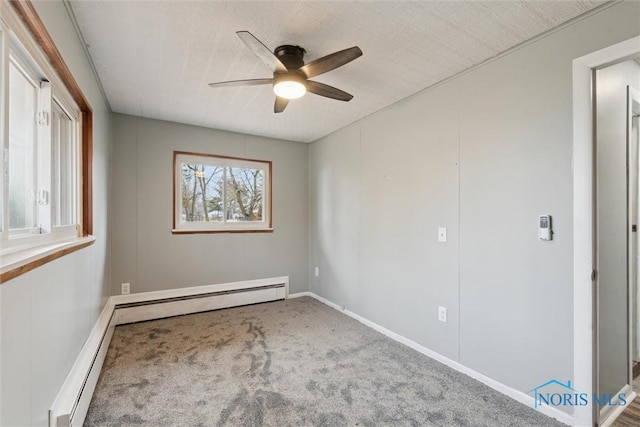 carpeted spare room with a baseboard radiator, ceiling fan, and baseboards