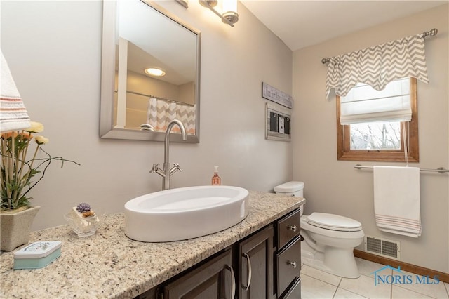 bathroom with tile patterned floors, vanity, and toilet