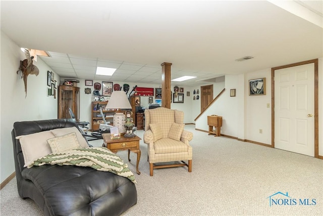 living area featuring a paneled ceiling and carpet floors