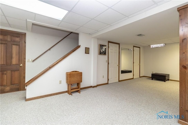 basement featuring carpet floors and a drop ceiling