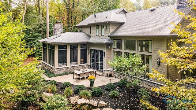 rear view of house featuring a patio and a sunroom