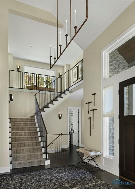 foyer entrance with hardwood / wood-style floors and a towering ceiling