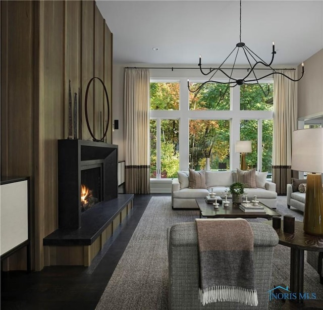 living room with a tiled fireplace, dark hardwood / wood-style floors, and a notable chandelier