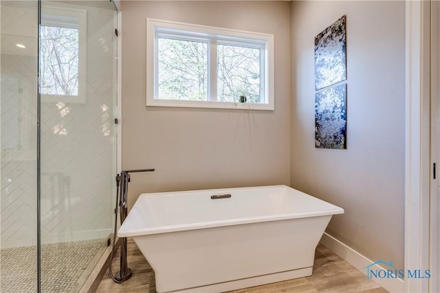 bathroom with hardwood / wood-style flooring and separate shower and tub