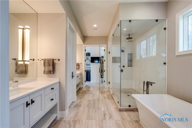 bathroom with vanity and independent shower and bath