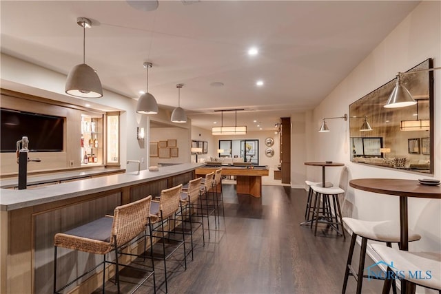 bar featuring dark wood-type flooring and pendant lighting