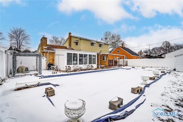 view of snow covered back of property