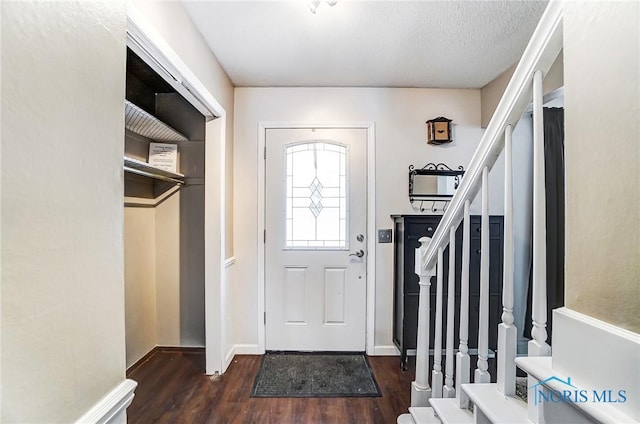 foyer with dark wood-type flooring and a textured ceiling