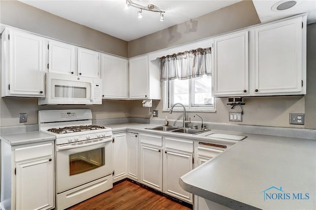 kitchen with dark hardwood / wood-style flooring, sink, white appliances, and white cabinets