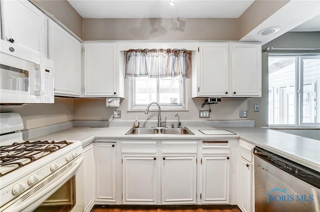 kitchen featuring white cabinetry, sink, and white appliances