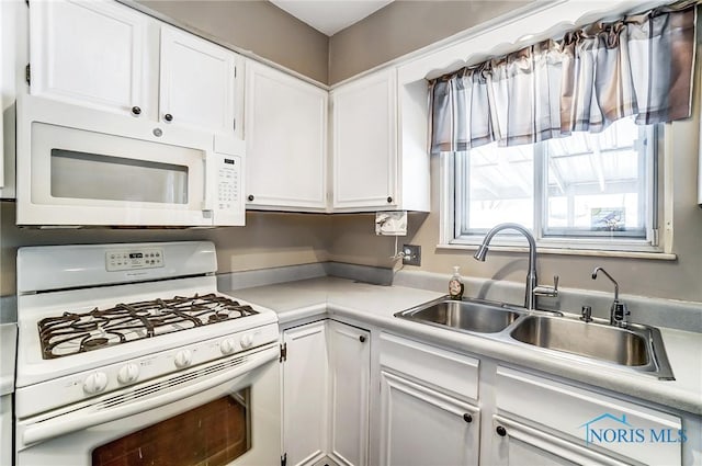 kitchen with white appliances, sink, and white cabinets