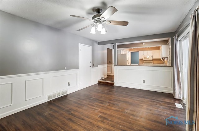 interior space with dark wood-type flooring and ceiling fan