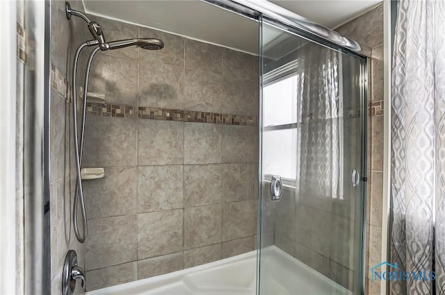 bathroom with shower / bath combination with glass door