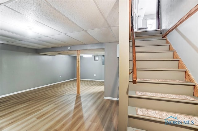 stairway featuring hardwood / wood-style floors and a paneled ceiling