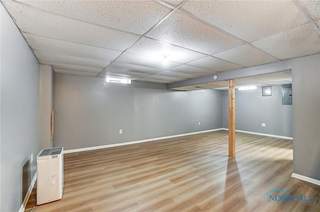 basement featuring a paneled ceiling and hardwood / wood-style floors