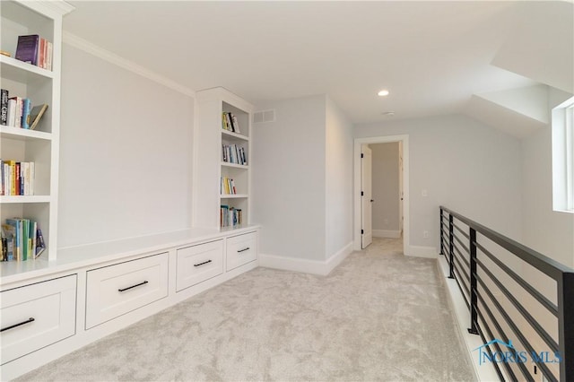 unfurnished room featuring light carpet and built in shelves