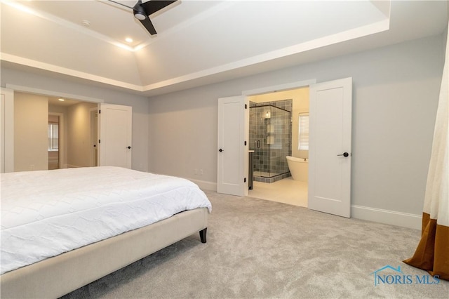 carpeted bedroom featuring ensuite bathroom, a tray ceiling, and vaulted ceiling