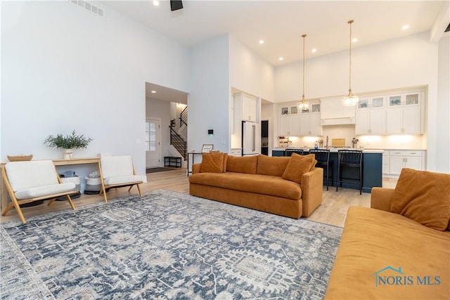 living room featuring a high ceiling and light hardwood / wood-style floors