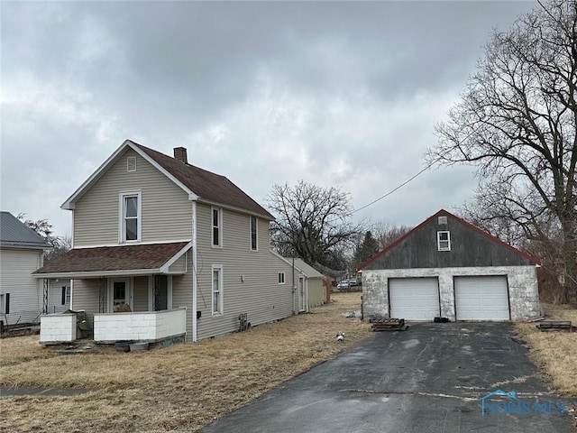 view of home's exterior with an outbuilding, a garage, and covered porch