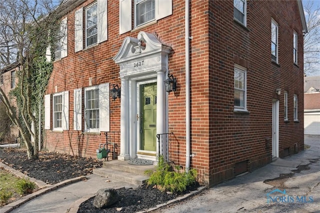 doorway to property featuring brick siding