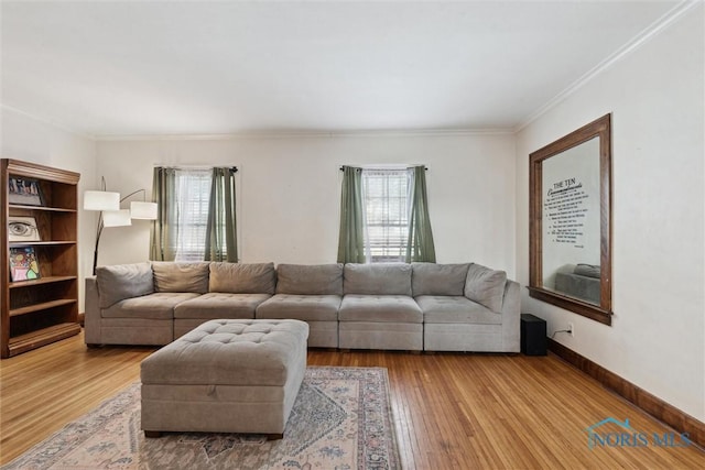 living area featuring baseboards, wood finished floors, and ornamental molding