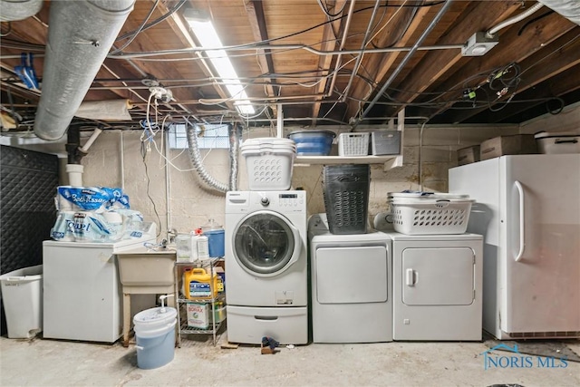 washroom with a sink, separate washer and dryer, and laundry area