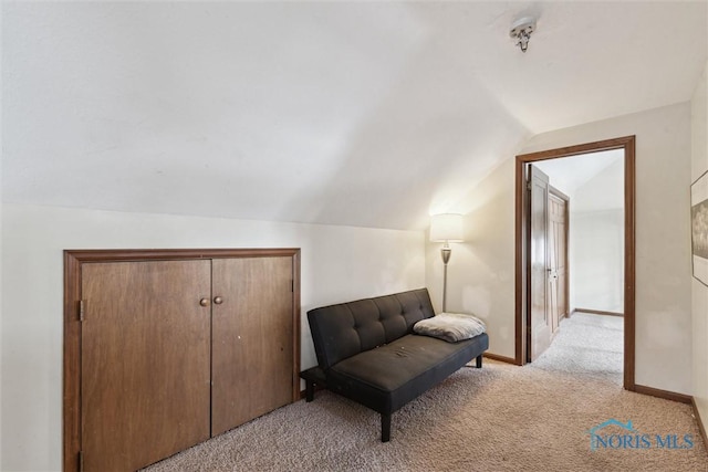 sitting room with baseboards, light carpet, and lofted ceiling