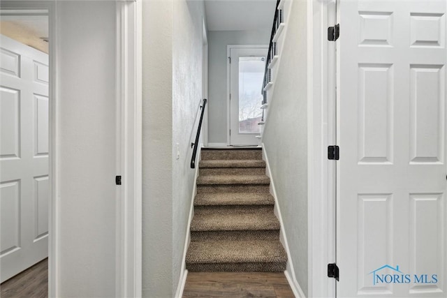 stairway featuring baseboards and wood finished floors