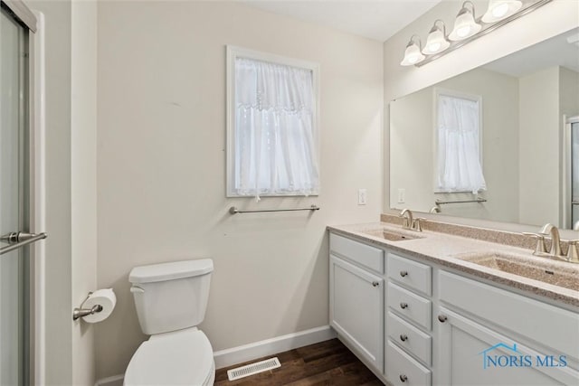 bathroom featuring double vanity, a sink, visible vents, and baseboards