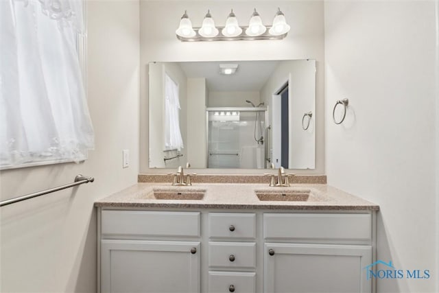 bathroom with double vanity, a sink, and a shower stall