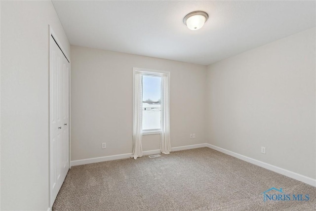 unfurnished bedroom featuring a closet, carpet flooring, and baseboards