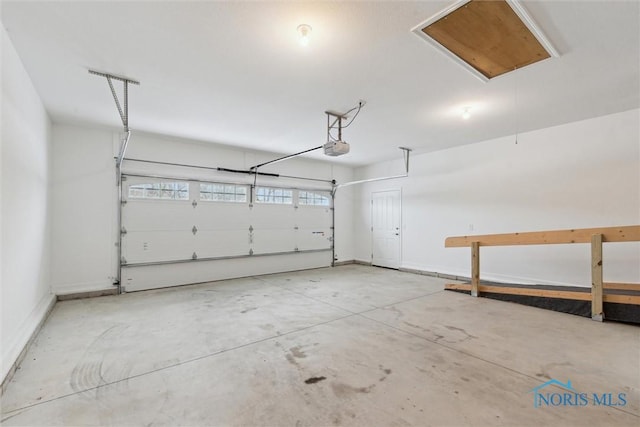 garage featuring a garage door opener and baseboards