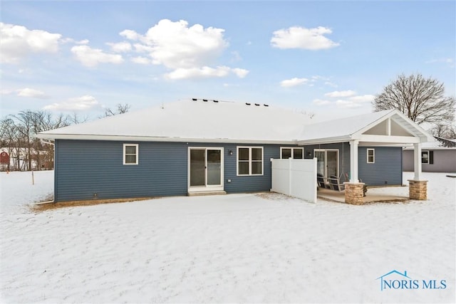 view of snow covered rear of property