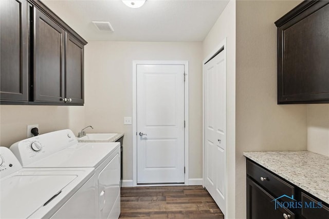 laundry area featuring cabinet space, visible vents, dark wood-style flooring, independent washer and dryer, and a sink